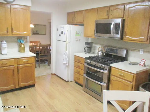 a kitchen with stainless steel appliances granite countertop a stove a refrigerator and a microwave