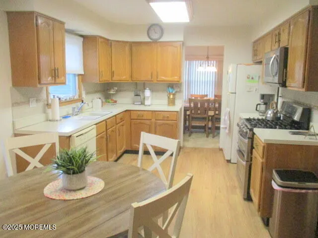 a kitchen with stainless steel appliances granite countertop a refrigerator a sink a stove and white cabinets
