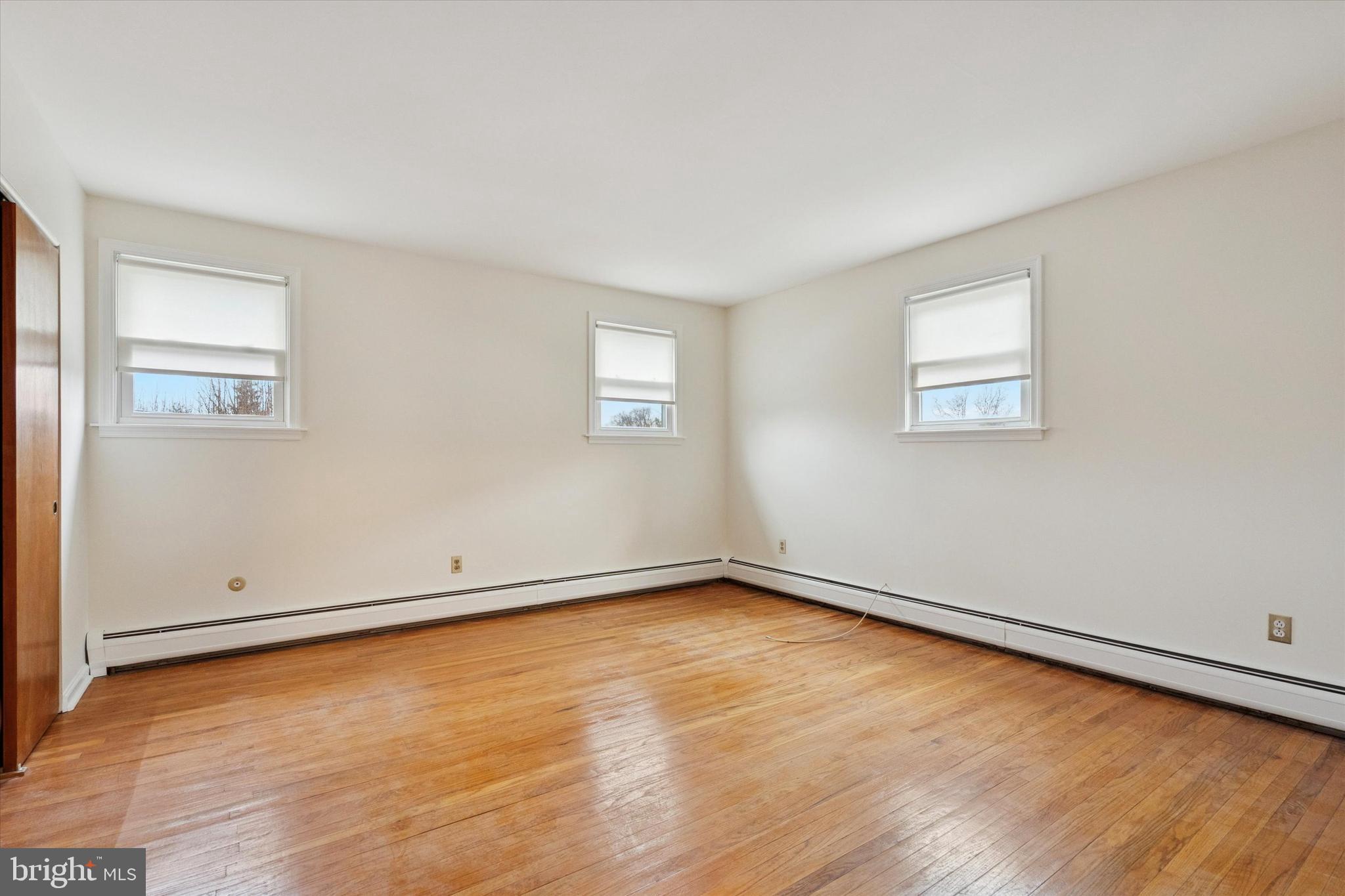 230 South Carol Boulevard, Unit B000 Upper Darby, PA 19082 - Photo 17 of 25 an empty room with wooden floor and windows