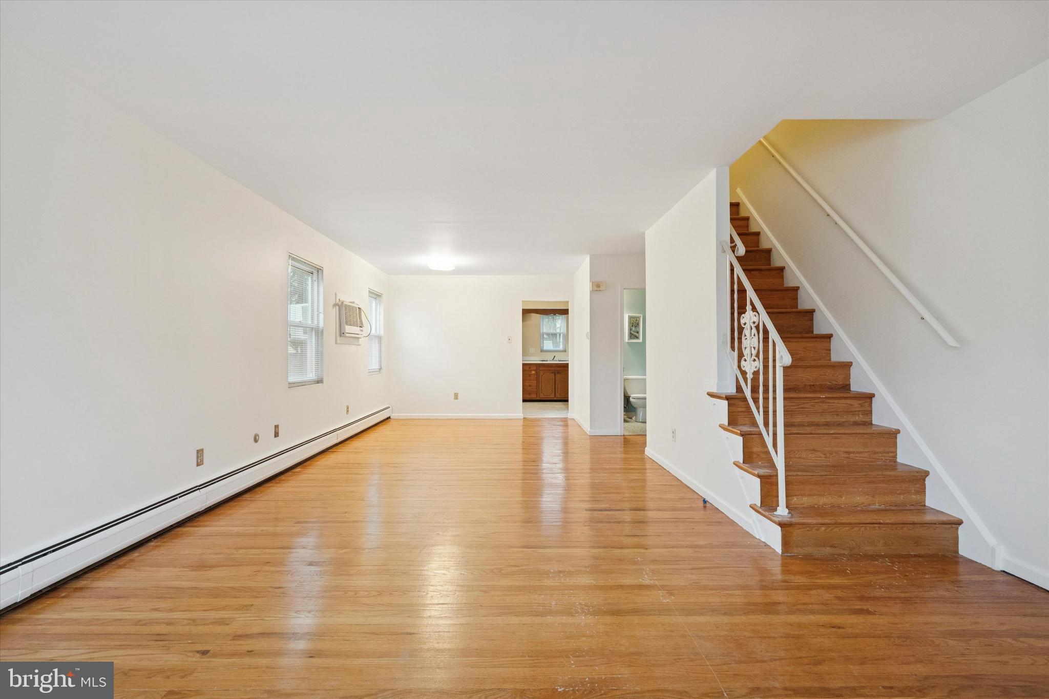230 South Carol Boulevard, Unit B000 Upper Darby, PA 19082 - Photo 3 of 25 a view of an empty room with wooden floor and stairs