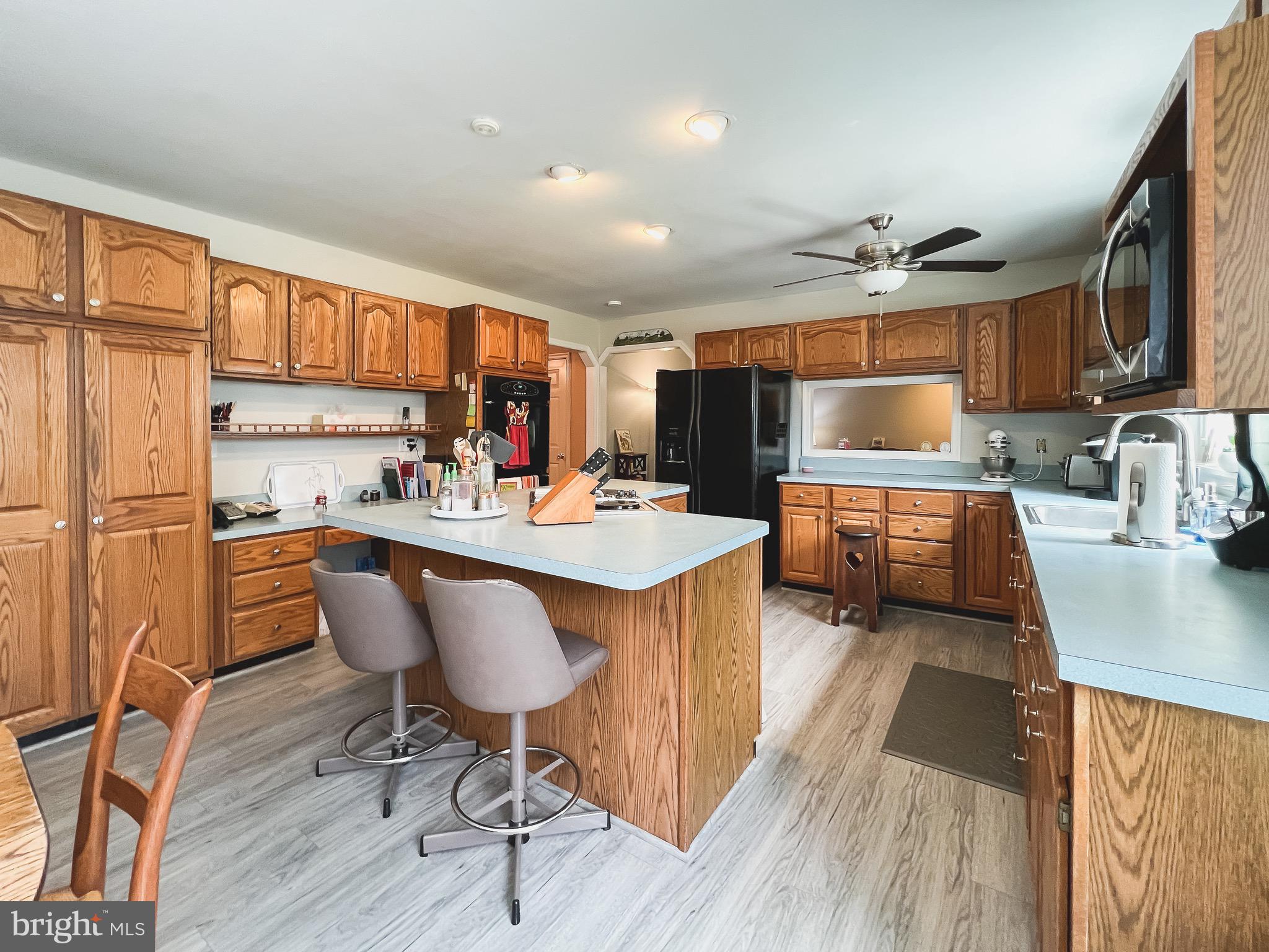 890 Carson Road Huntingtown, MD 20639 - Photo 6 of 64 a open kitchen with stainless steel appliances granite countertop a sink dishwasher a stove a refrigerator with island and chairs with wooden floor