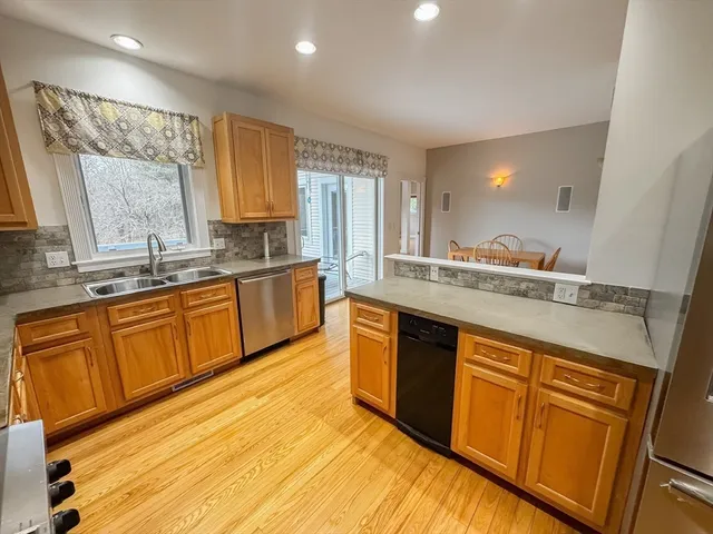 a large kitchen with stainless steel appliances granite countertop sink stove and cabinets