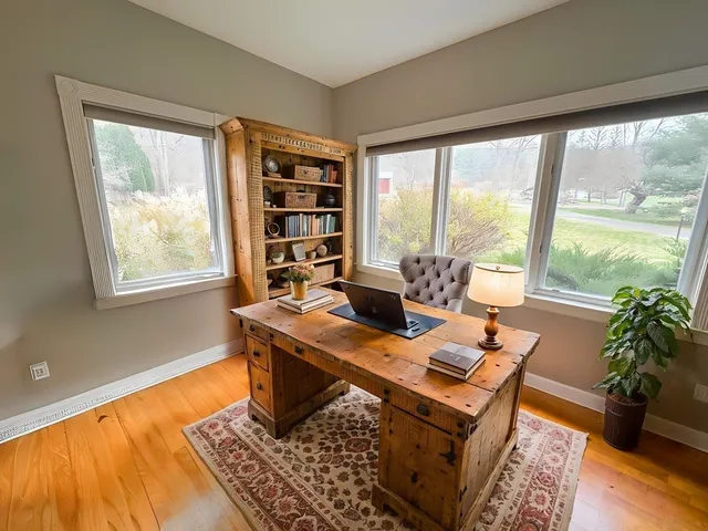 a view of a workspace with furniture and a window