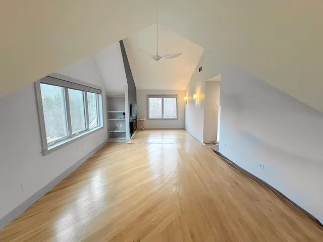 a view of hallway with wooden floor and stairs