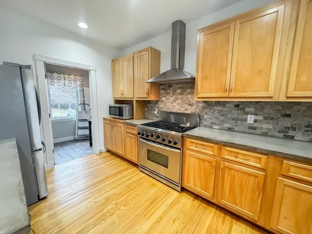 a kitchen with stainless steel appliances granite countertop a stove a sink dishwasher and a refrigerator