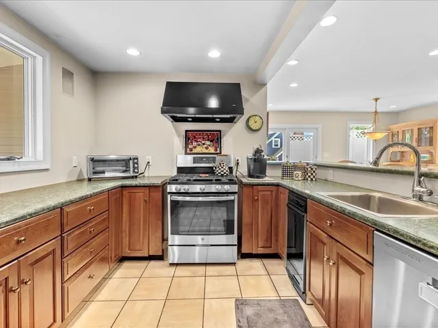 a kitchen with stainless steel appliances a dining table chairs and granite counter tops