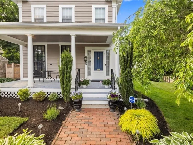 a front view of a house with a yard and potted plants