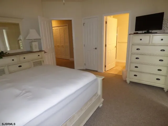 a spacious bedroom with a bed and flat screen tv