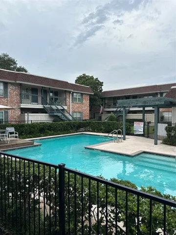 a view of a house with pool and chairs