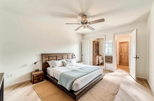 a bedroom with a large bed and a chandelier