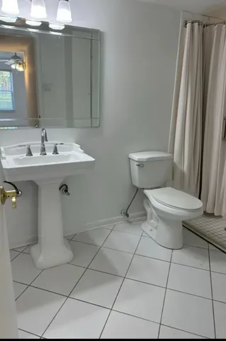 a bathroom with a sink toilet and mirror