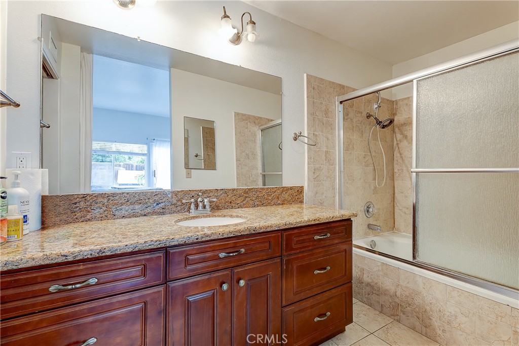 32 Blazing Star Irvine, CA 92604 - Photo 15 of 21 a bathroom with a granite countertop sink a mirror and a shower