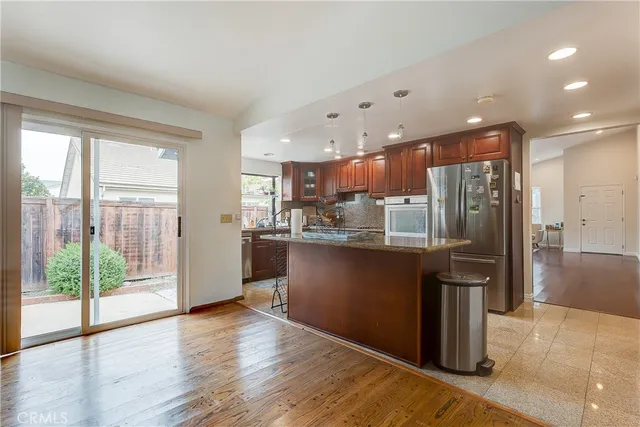 a kitchen with stainless steel appliances granite countertop a refrigerator and a sink
