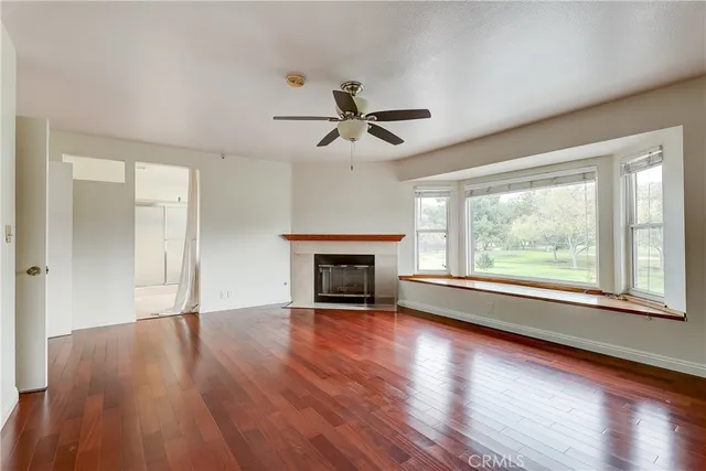 wooden floor fireplace and windows in an empty room