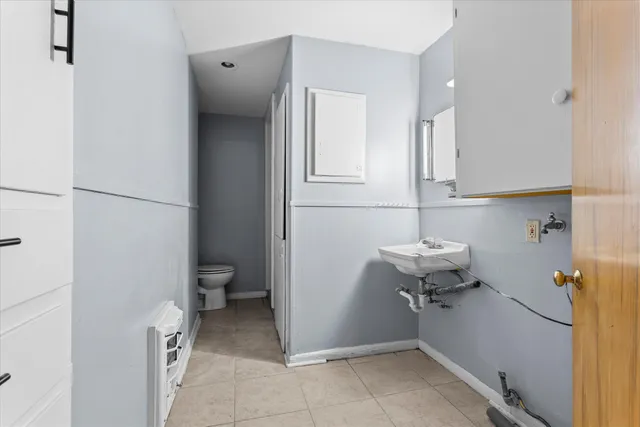 an empty room with windows and chandelier fan