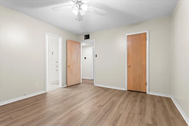 a view of empty room with wooden floor