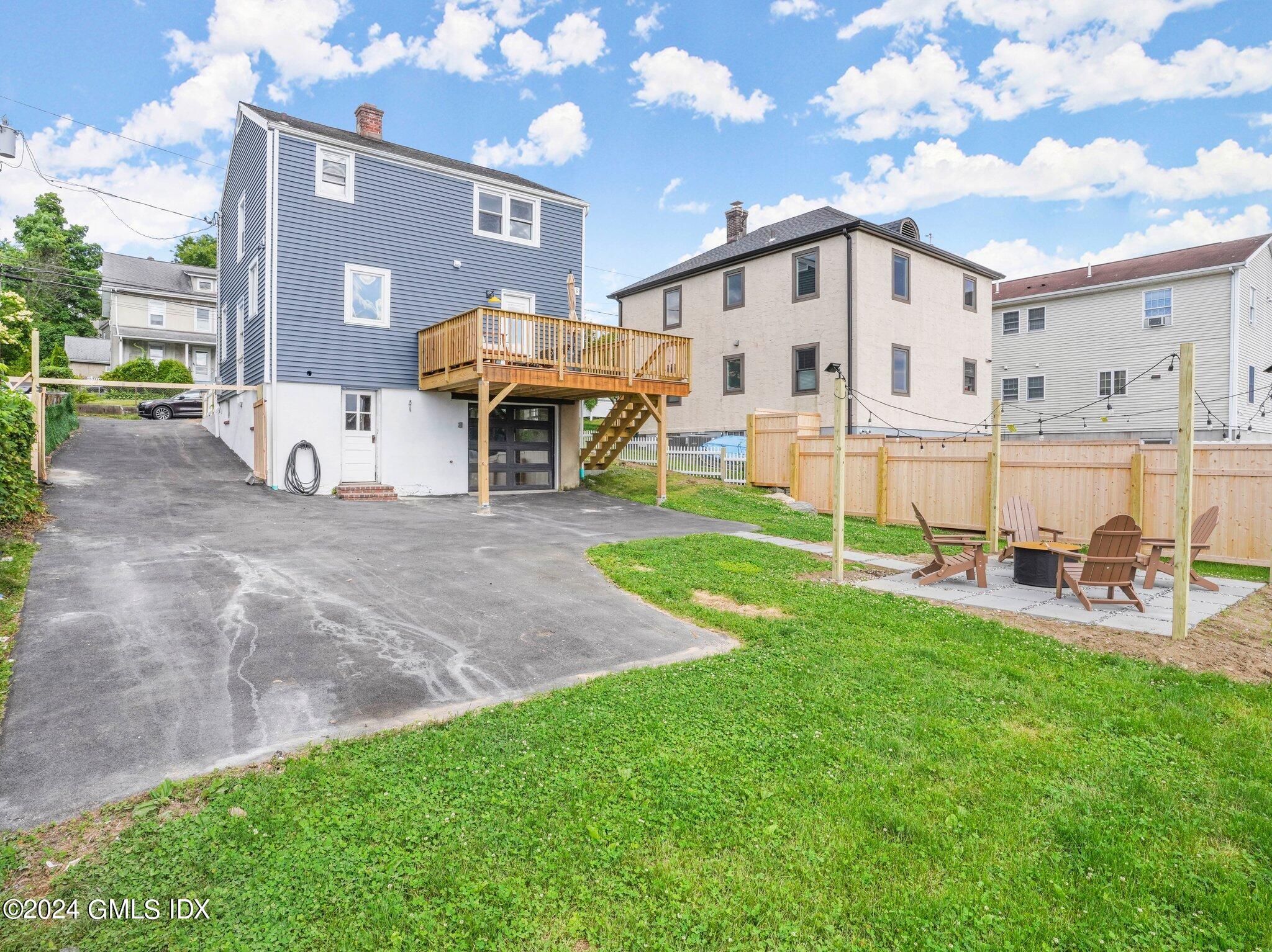 108 Henry Street Greenwich, CT 06830 - Photo 2 of 20 a view of a white house with a yard and chairs