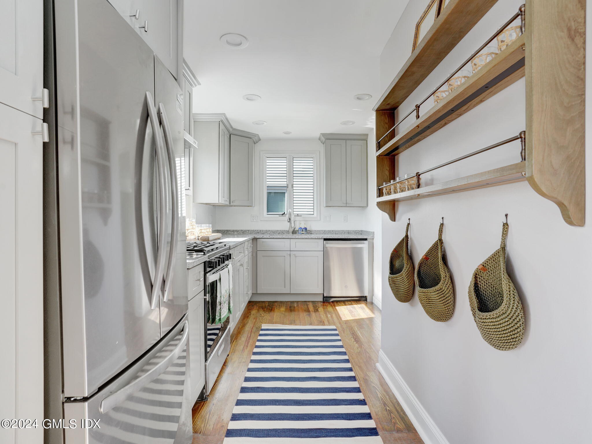 108 Henry Street Greenwich, CT 06830 - Photo 9 of 20 a kitchen with white cabinets and refrigerator