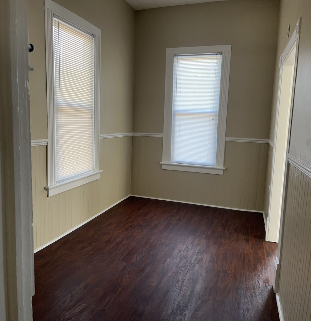 1301 18th Street, Unit B Columbus, GA 31901 - Photo 11 of 18 an empty room with wooden floor and windows