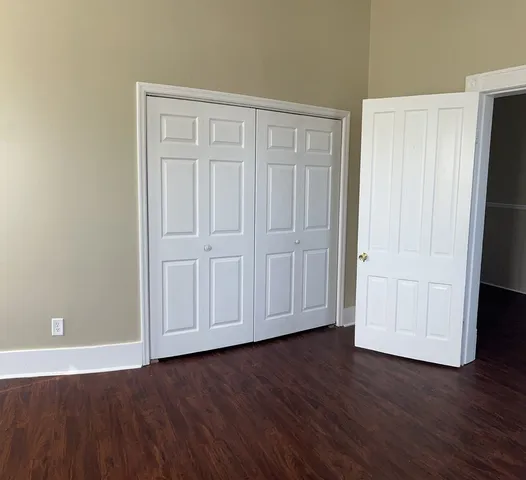 a view of empty room with wooden floor and entryway