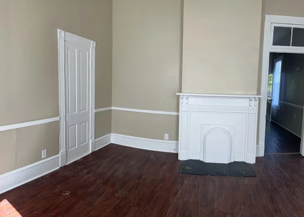 a view of a hallway with wooden floor and a window