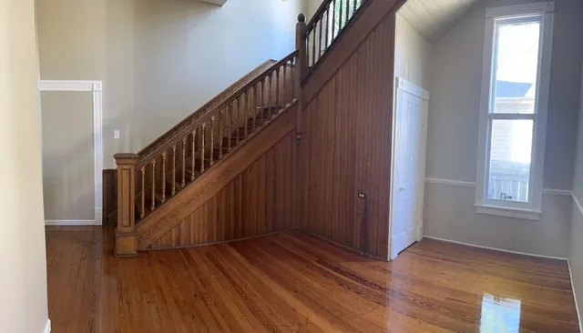 a view of staircase with wooden floor and white walls