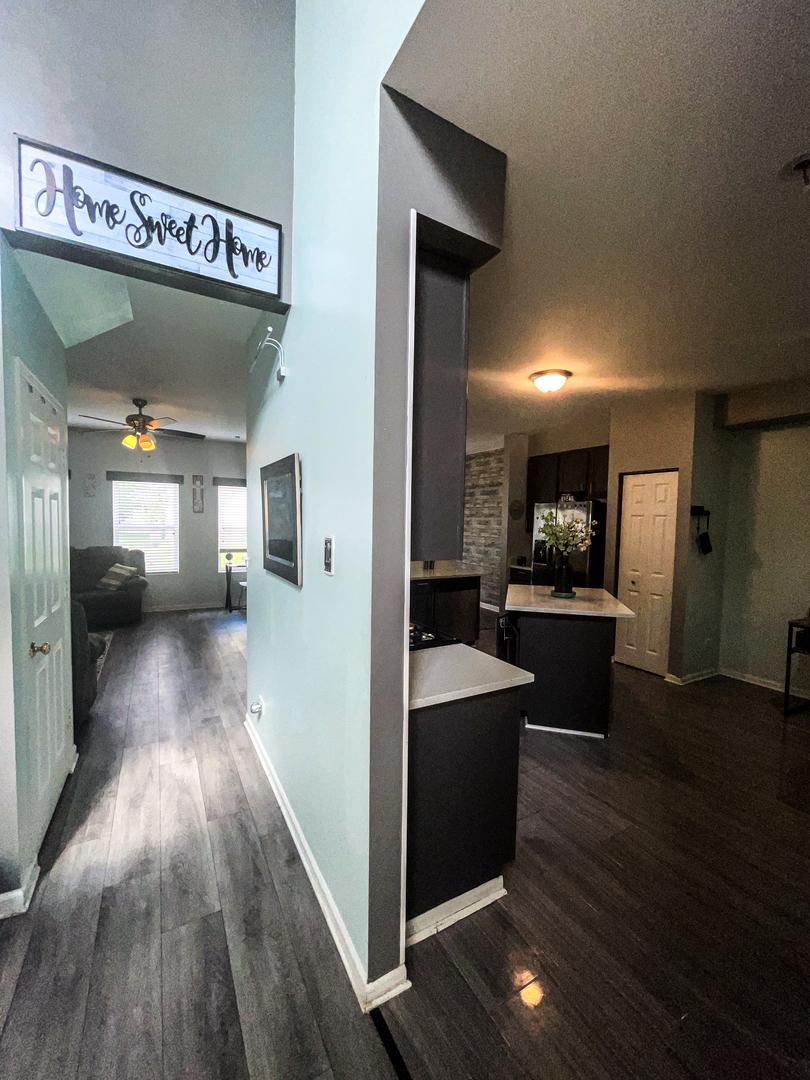 21528 Eich Drive Crest Hill, IL 60403 - Photo 7 of 23 a view of a hallway with wooden floor windows and a kitchen