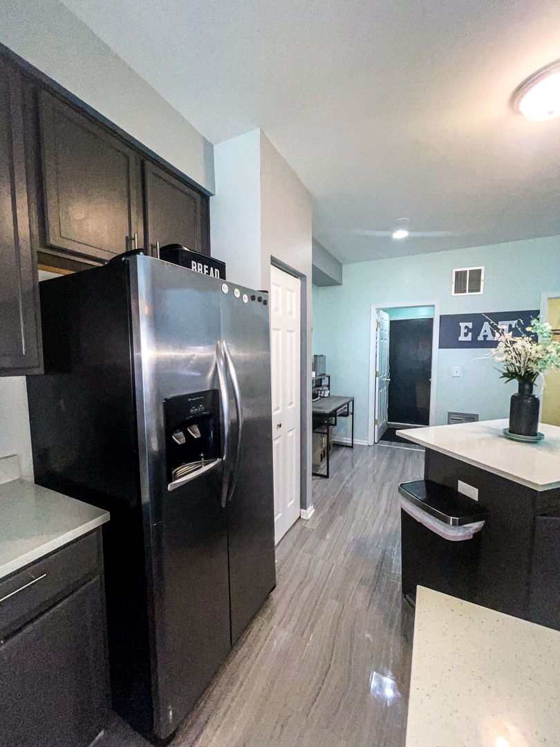 21528 Eich Drive Crest Hill, IL 60403 - Photo 10 of 23 a kitchen with stainless steel appliances kitchen island granite countertop a refrigerator and a stove