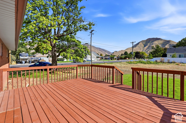 380 North 300 East Mapleton, UT 84664 - Photo 29 of 35 Expansive outdoor deck with wood railing, offering broad mountain scenery and a mature shade tree