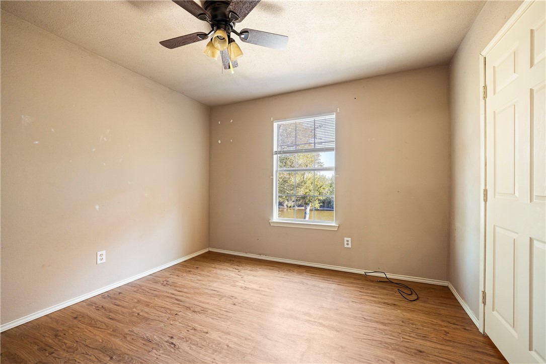 333 Mission River Oaks Road Woodsboro, TX 78393 - Photo 11 of 26 an empty room with a chandelier fan and windows