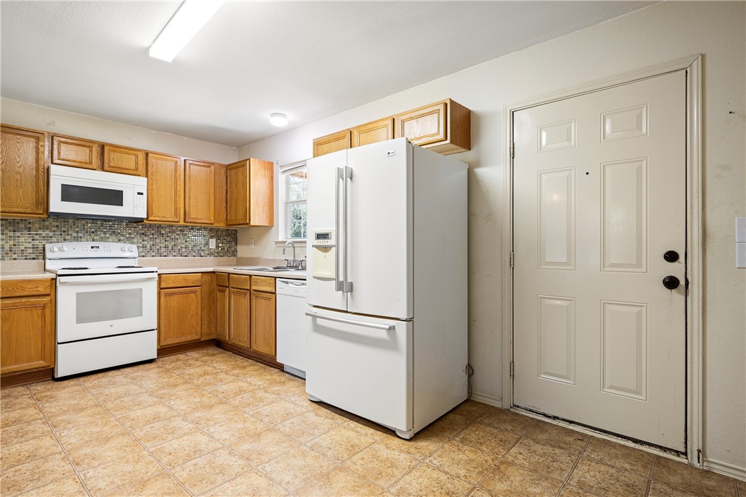 333 Mission River Oaks Road Woodsboro, TX 78393 - Photo 15 of 26 a kitchen with cabinets stainless steel appliances and a window