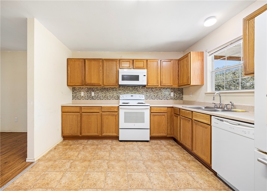 333 Mission River Oaks Road Woodsboro, TX 78393 - Photo 18 of 26 a kitchen with a stove a sink and a microwave