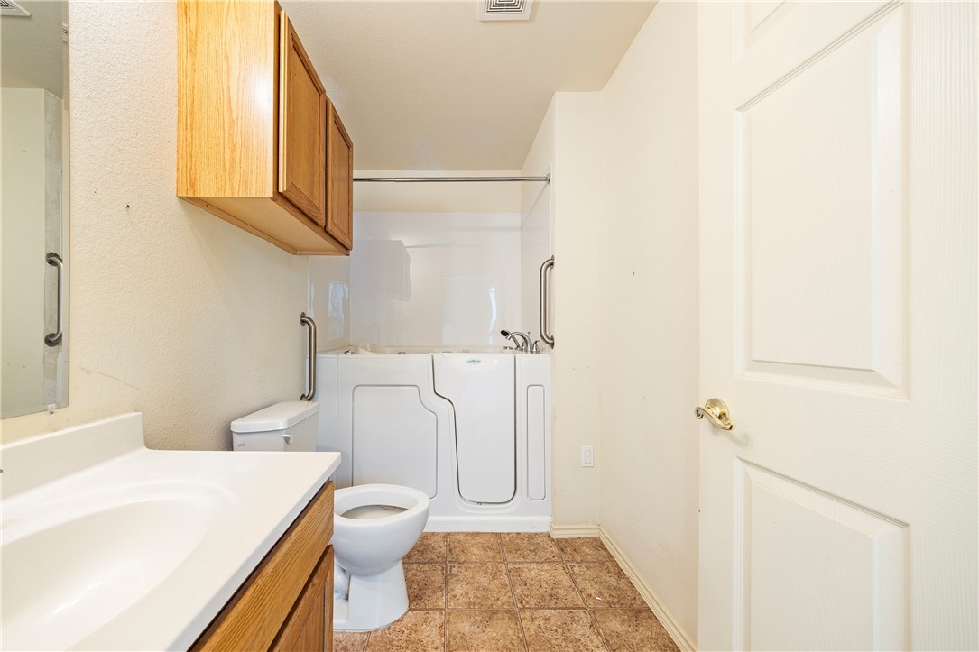 333 Mission River Oaks Road Woodsboro, TX 78393 - Photo 22 of 26 a white toilet sitting next to a bathroom sink