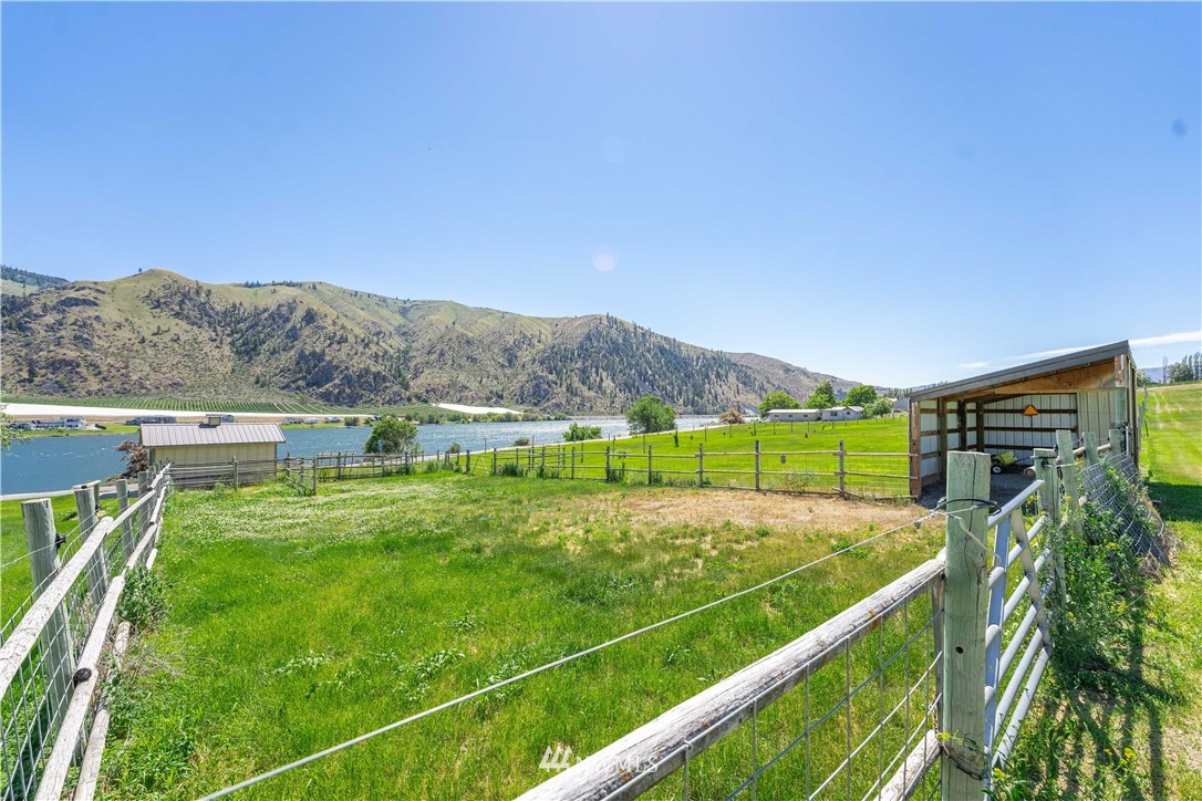 485 Stayman Flats Road Chelan, WA 98816 - Photo 15 of 32 a view of a swimming pool with a garden and mountain view