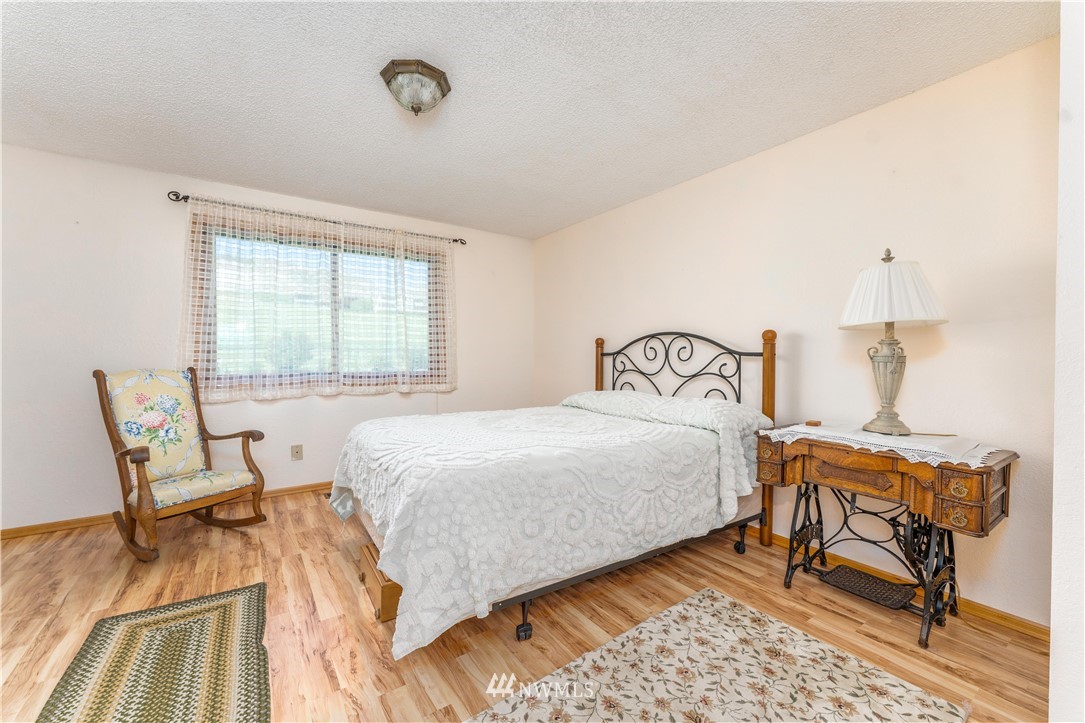 485 Stayman Flats Road Chelan, WA 98816 - Photo 6 of 32 a bedroom with a bed a chair and next to a window