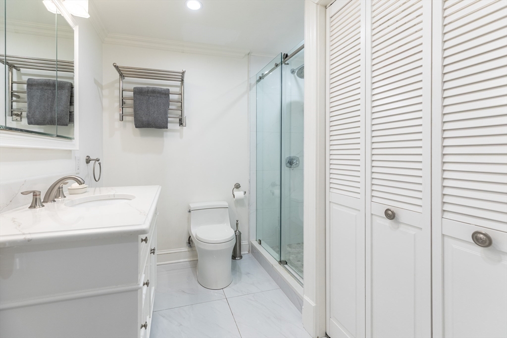 461 Beacon Street, Unit 1 Boston, MA 02115 - Photo 6 of 8 a bathroom with a toilet sink vanity and mirror
