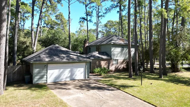 an empty room with wooden floor fireplace and windows