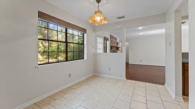 en empty room with windows and chandelier