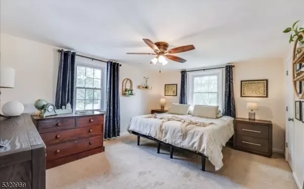 a bedroom with a bed a chandelier and a television