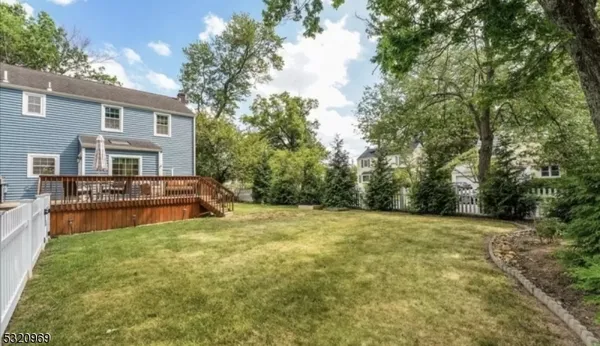 a view of a house with a big yard and large tree