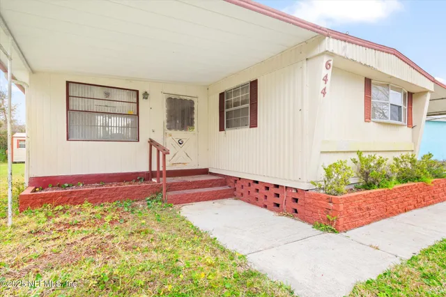a backyard of a house with table and chairs
