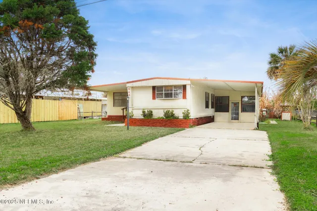 a view of a house with a yard and sitting area