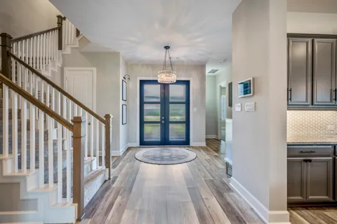 a view of a hallway with wooden floor and staircase
