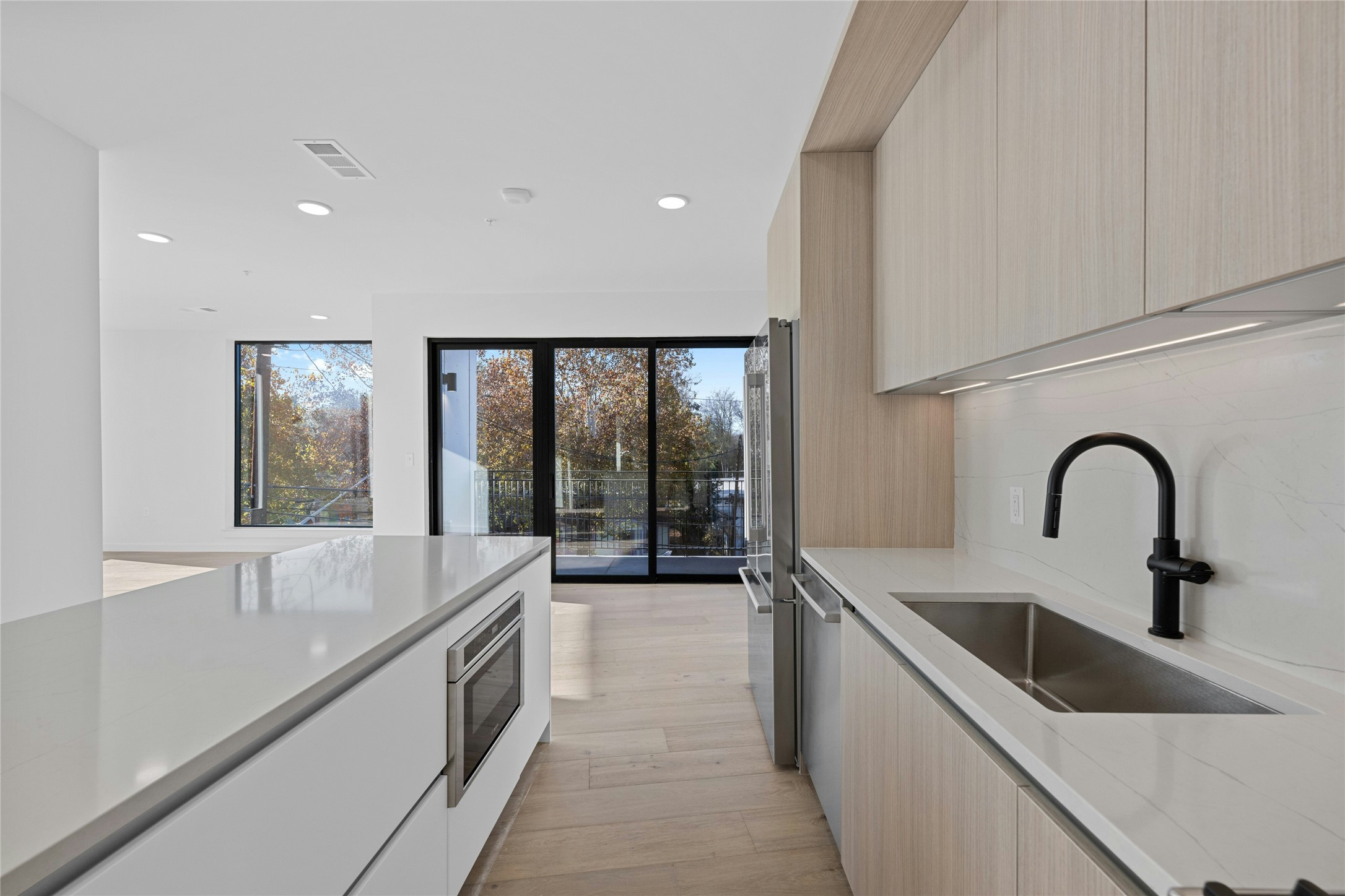 2209 South 1st Street, Unit 321 Austin, TX 78704 - Photo 5 of 40 Kitchen with modern cabinets, light stone counters, and recessed lighting