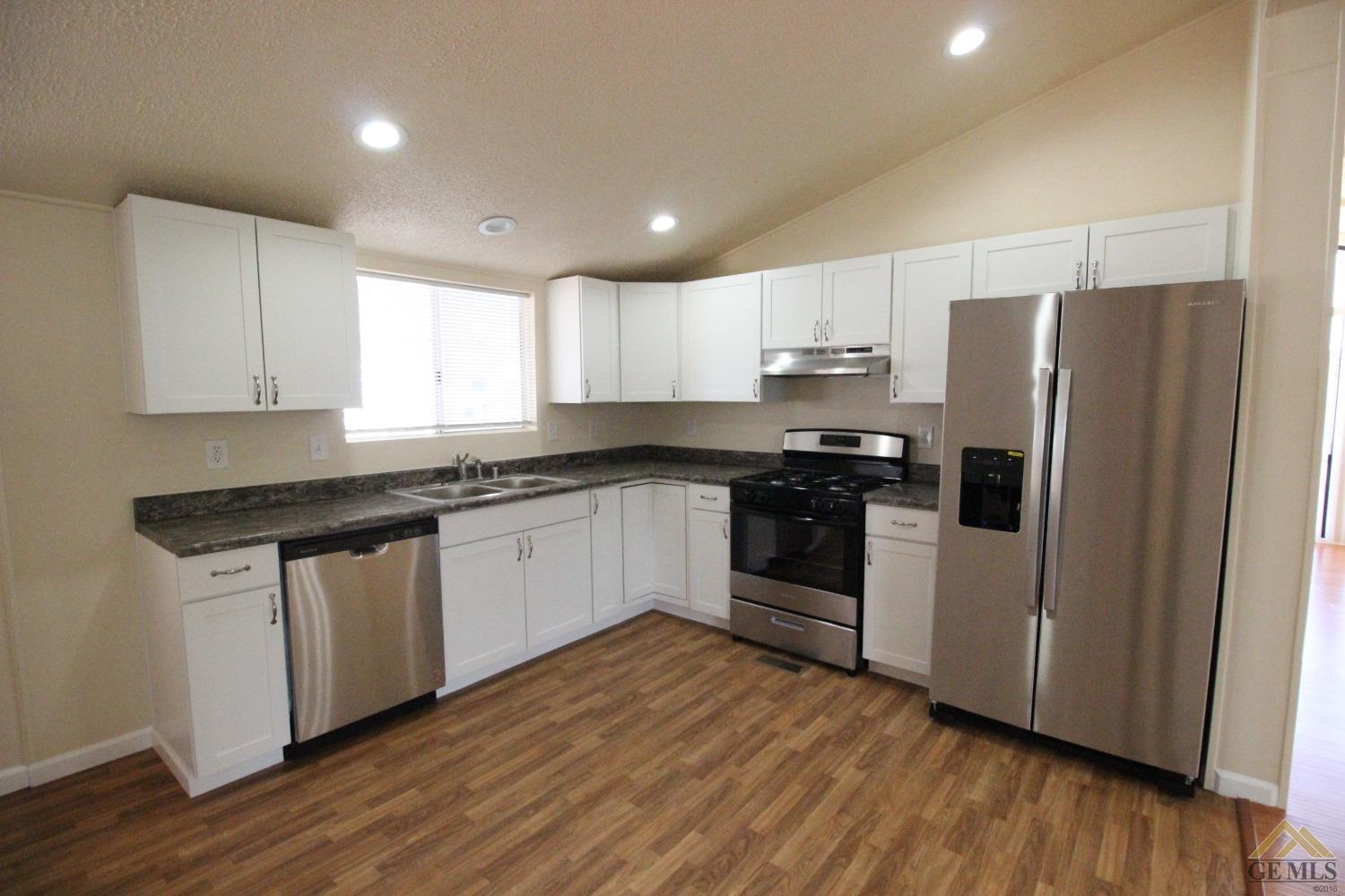Undisclosed Address Bakersfield, CA 93308 - Photo 12 of 26 a kitchen with granite countertop white cabinets and stainless steel appliances