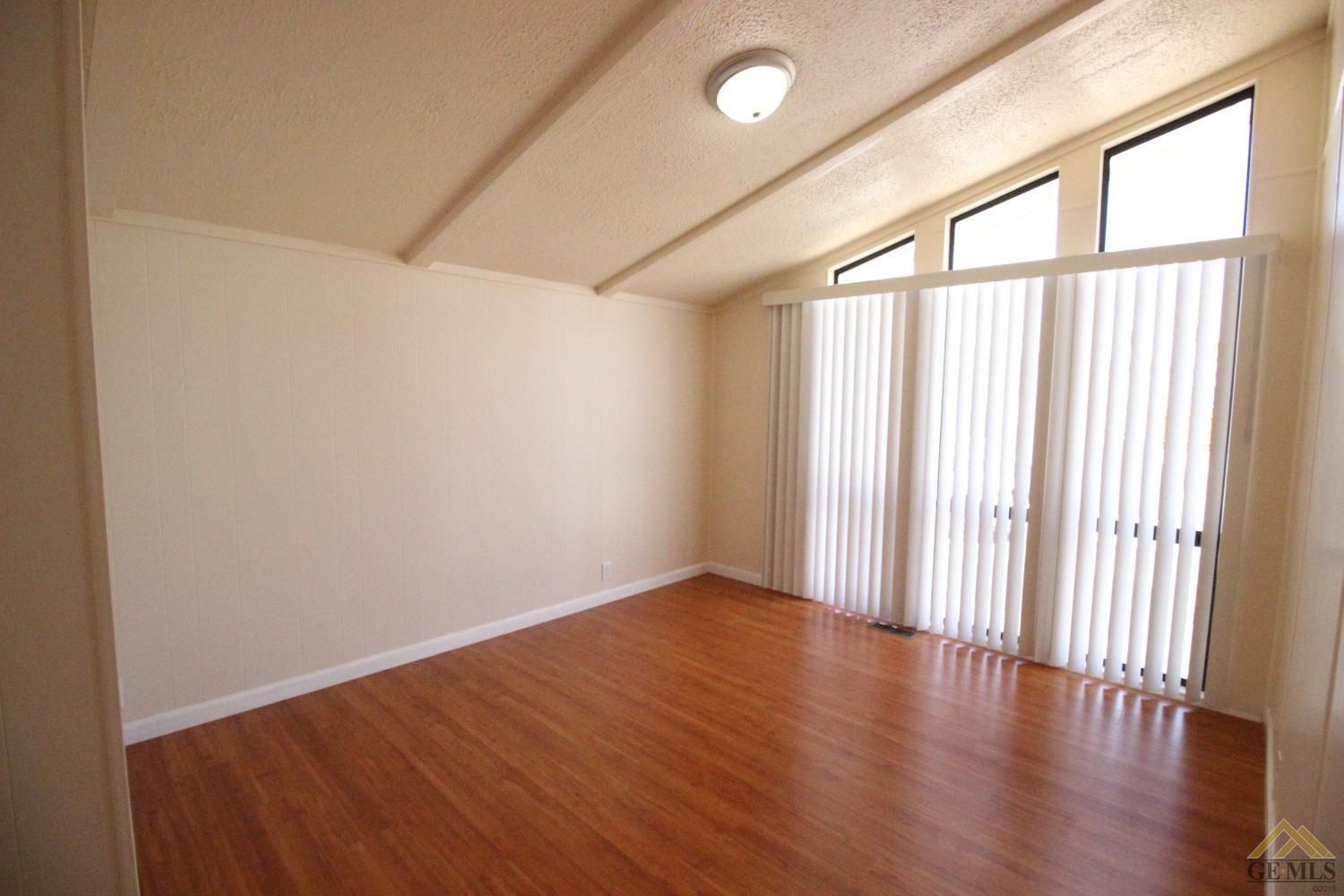 Undisclosed Address Bakersfield, CA 93308 - Photo 17 of 26 an empty room with wooden floor and windows