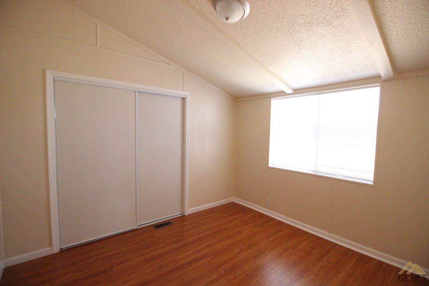 Undisclosed Address Bakersfield, CA 93308 - Photo 18 of 26 an empty room with wooden floor and windows