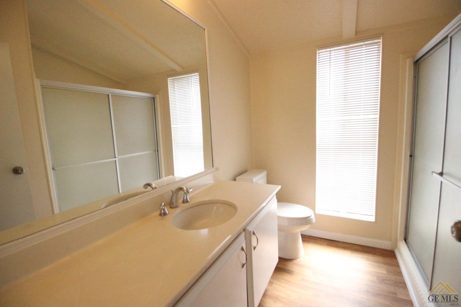Undisclosed Address Bakersfield, CA 93308 - Photo 19 of 26 a bathroom with a granite countertop sink a toilet and shower