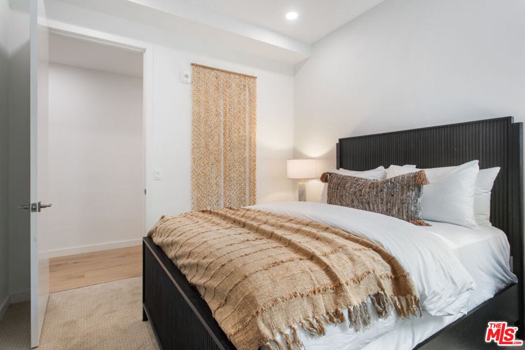 10310 Santa Monica Boulevard, Unit 216 Los Angeles, CA 90025 - Photo 13 of 38 a bed sitting in a bedroom next to a bathroom