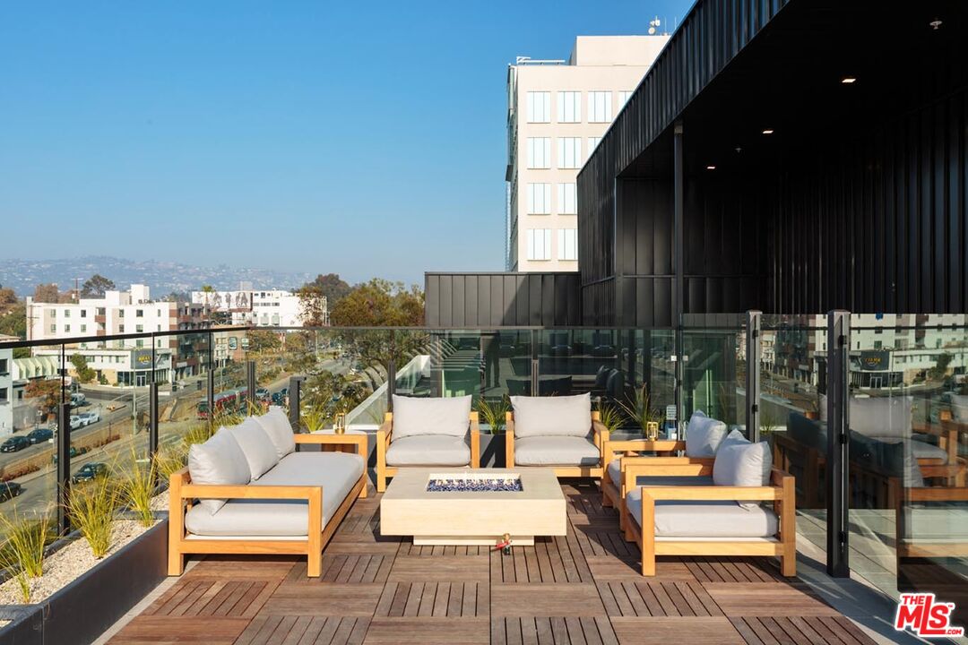 10310 Santa Monica Boulevard, Unit 216 Los Angeles, CA 90025 - Photo 27 of 38 a view of a balcony with chairs and wooden floor